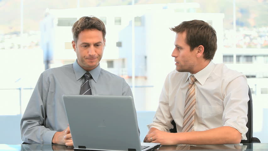 Coworkers looking at the laptop