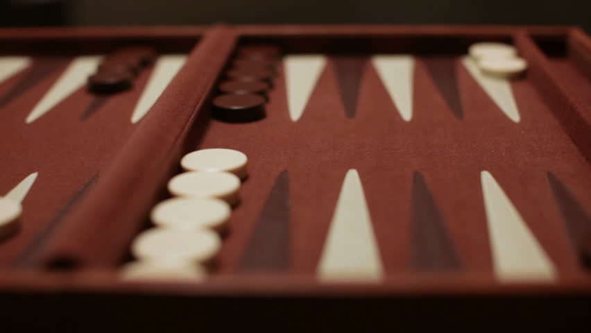 A backgammon player rolls and the scoops up the dice