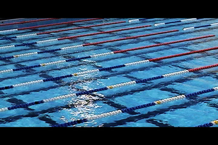 swimmers swim by camera in olympic sized pool