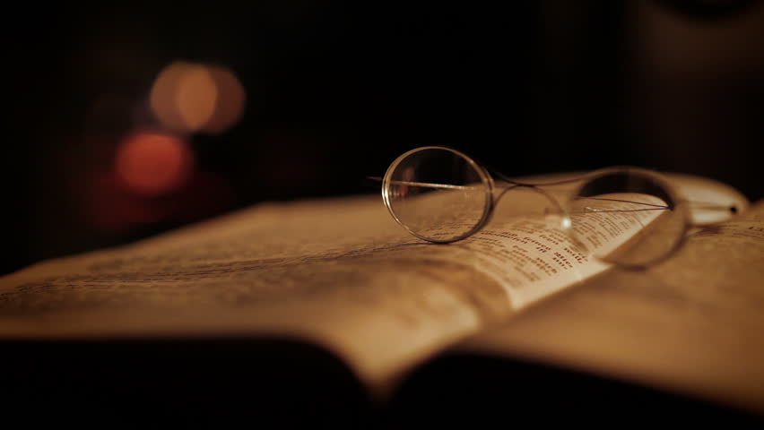 Pair of old glasses on a book