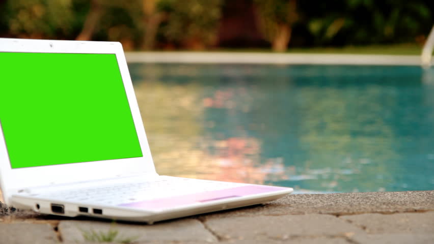 Laptop with green screen near to swimming pool 
