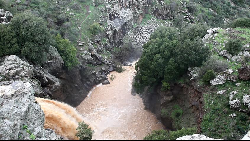 Banias Falls in the winter at the Golan Heights (Israel). Orange color of water because of washout of the earth from fields as a result of heavy rains.  