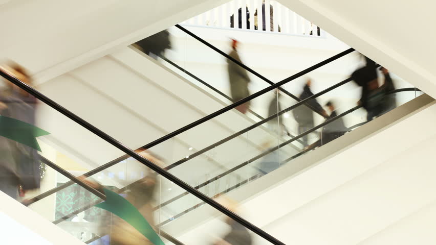 People on fast moving escalator in public building  