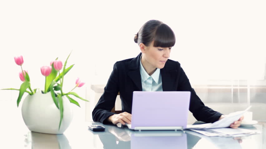 Overworked businesswoman sitting by the desk in the office