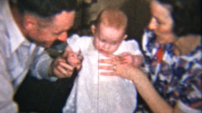 A proud mom and dad spend time with their beautiful red headed baby girl. from 8mm reels 