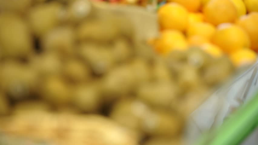 Woman at supermarket, choosing lemon