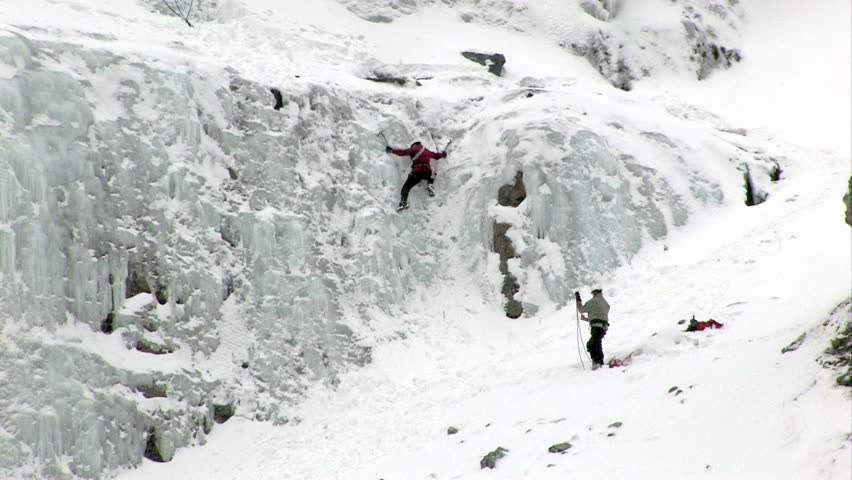 Video of ice climbers climbing ice flow at Bridal Vale Falls in central Utah. Small step. Steep rock ledges with frozen waterfall. Athletic sport in cold weather. Wasatch Mountain range. 