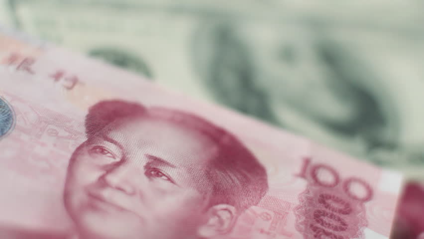 Rack focus from Chinese 100 Yuan note to 100 US dollar bill and back