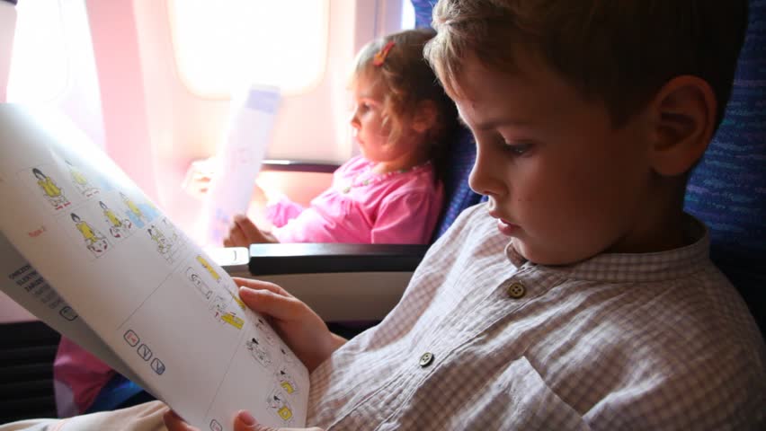 boy and girl read behavior rules safety instruction in plane