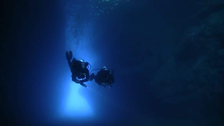Scuba divers in cave exit