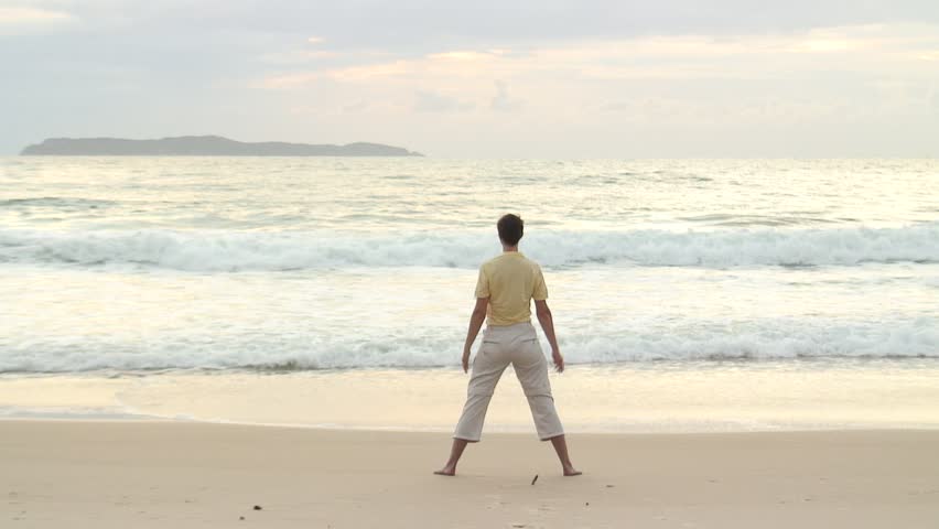HD 1080i: Young woman doing yoga on the beach at sunrise in Bombinhas - Brazil. Tripod.