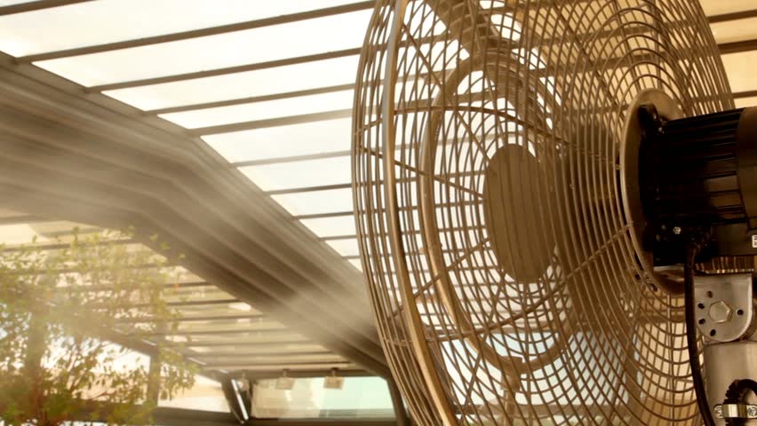 Airflow from the fan atomizes a jet of water on plants, fan rotates from side to side