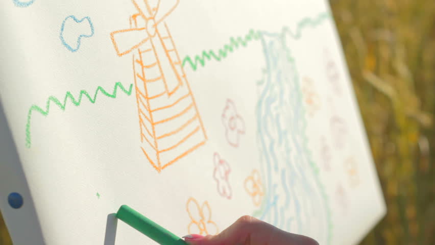 Fascinating drawing lesson outdoors in meadow between woman and boy  