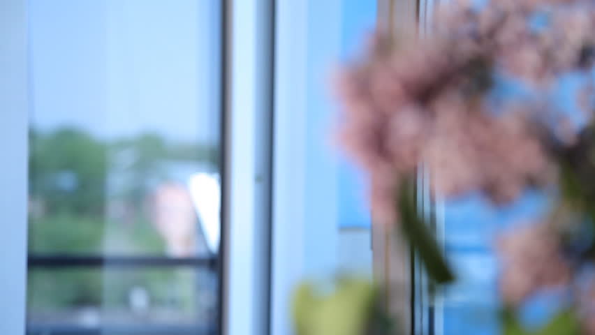 Man takes a pill while standing at the window