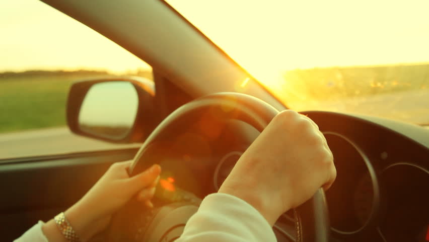 Sunset drive. Driving in the country, with sun going down. Shallow depth of field. Additional colour processing in post to add warmth.  