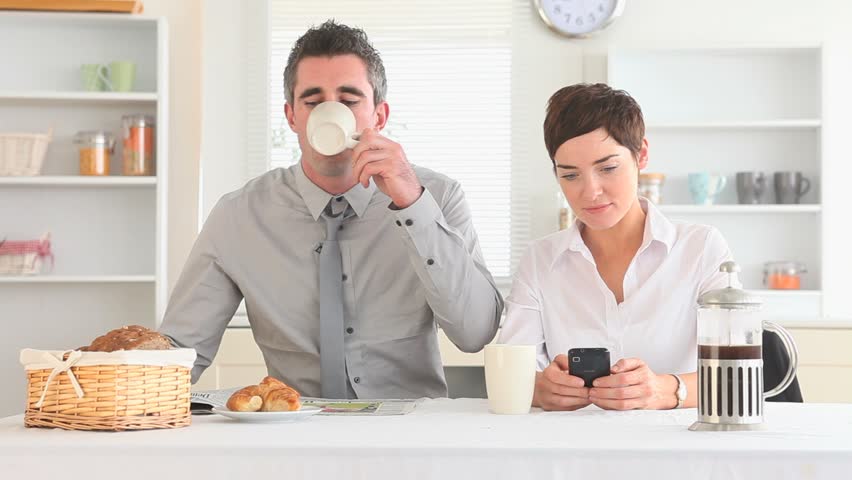 Couple hurrying to work after breakfast in the kitchen