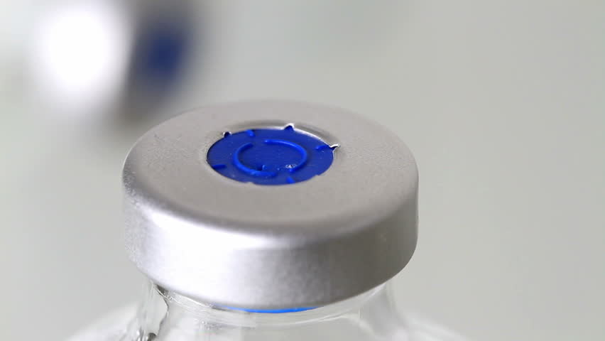 medical/medicine injection vials, macro close up with camera motion, hand takes bottle.