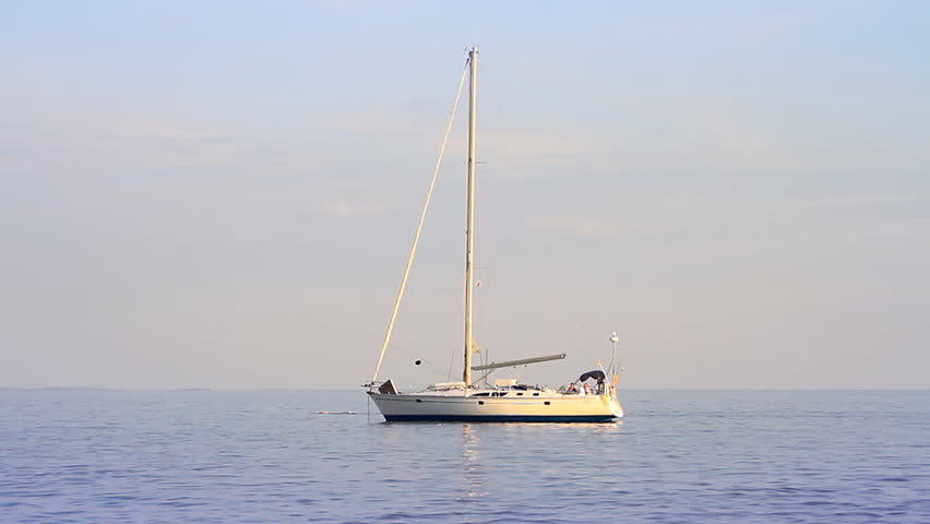 Seascape, a yacht anchored, rippling water surface, swimmer in a distance   
