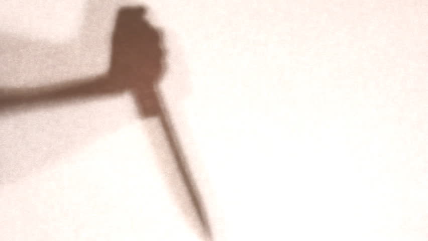 Hand with knife in shadow