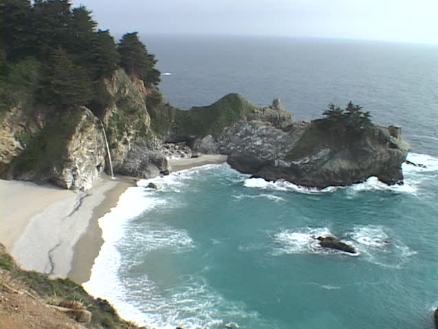 A waterfall spills onto the sandy beach in Big Sur.