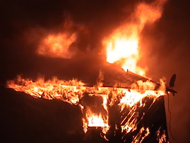 Flames engulfing a house at night