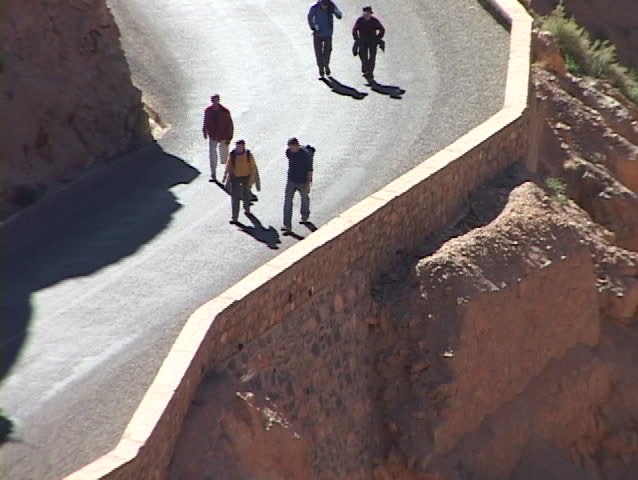 Hikers walk up a very steep, winding canyon trail.