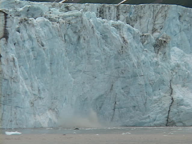 A glacier calves into the ocean.