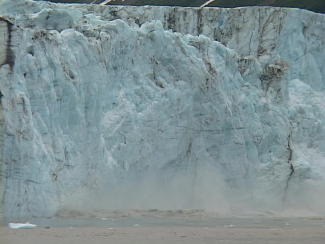 A glacier calves into the ocean.