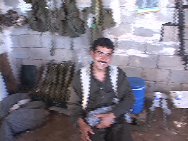 IRAQ - CIRCA 2003: A weapons dealer in Northern Iraq proudly poses with his arsenal circa 2003 in Iraq.