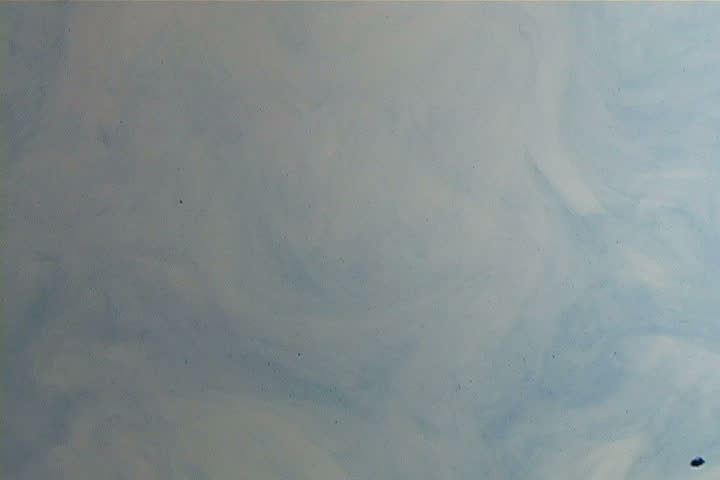 Red ink elegantly flowing in a liquified chamber.