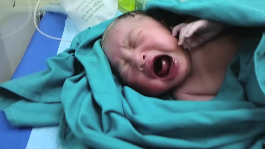 Newborn baby crying at delivery room.