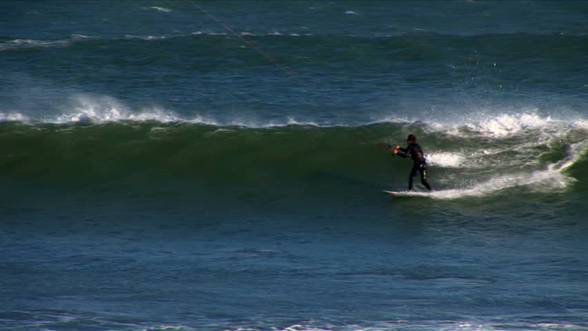 Kiteboarder doing strong cutbacks on wave