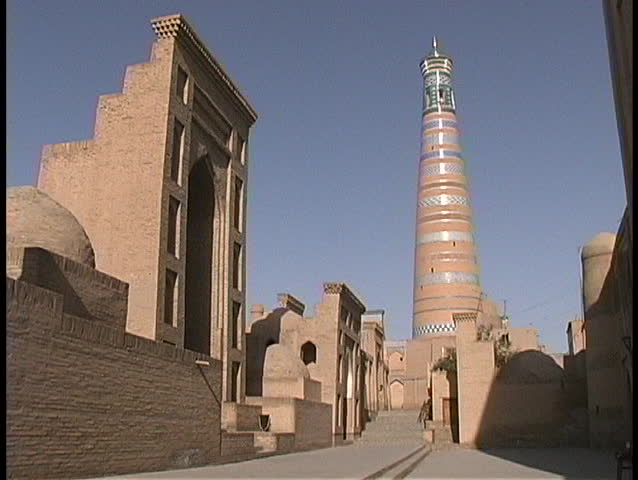 A mosque and minaret adorn the blue sky in Khiva, Uzbekistan.