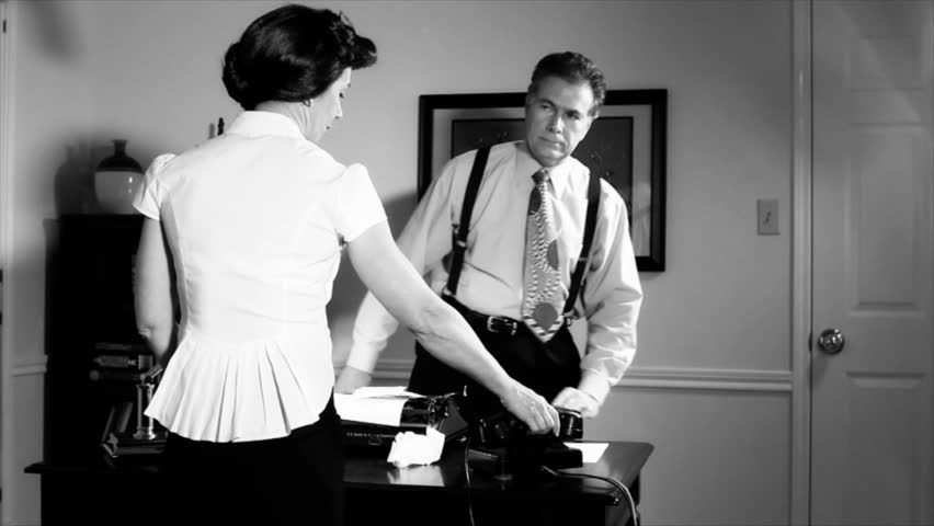 A scene set in the 1940's of a woman making a phone call from a vintage rotary phone while a man leaves the room walking straight towards the camera. Black and White, Film Noir Genre