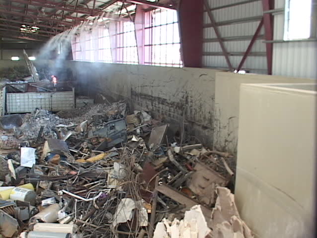 Workers unload scrap metal in a large recycling center.