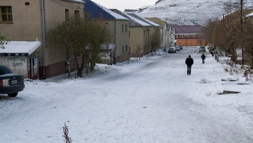 People walk on the streets of an Argentina or Chile town in winter.