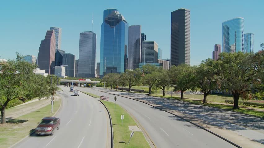 Cars drive along a highway leading into downtown Houston.