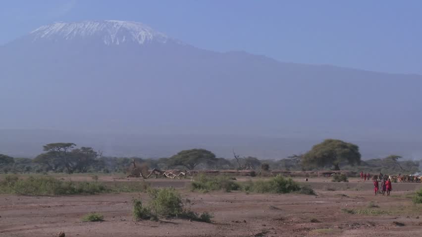 Masai warriors walk in in front of Mt. Kilimanjaro in Tanzania, East Africa.
