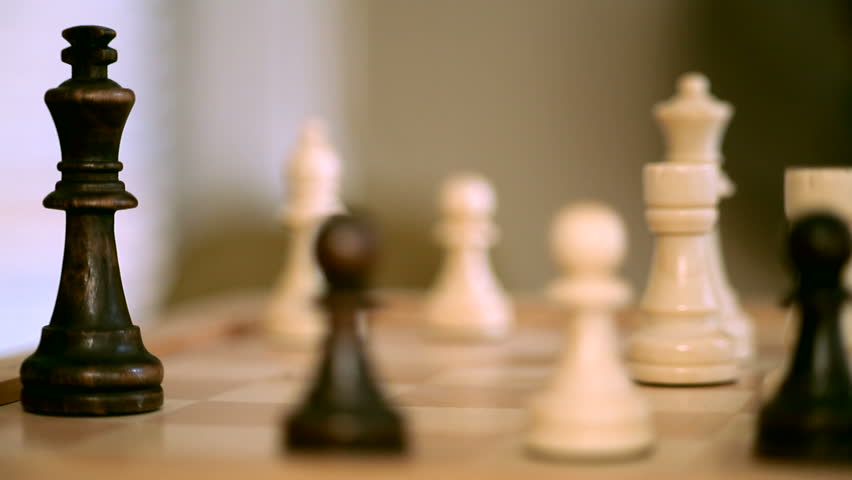 White chess player knocks down the black king with his piece