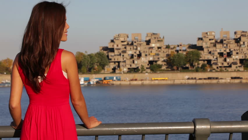 Woman enjoying view in old port of Montreal, Canada. Beautiful young mixed race Asian Caucasian female model in red dress