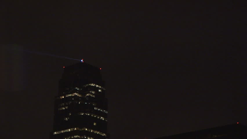 night view of a large office building with a warning beacon turning on top