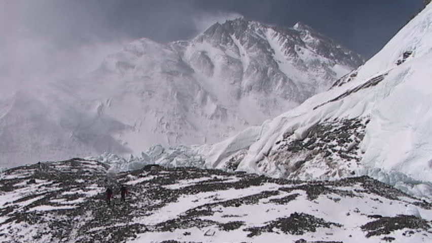 Climbers walking in the distance with Mt. Everest pinnacles and summit in the background