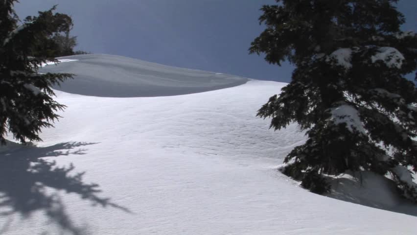 Snowboarder passing and leaving powder on the lens of the camera