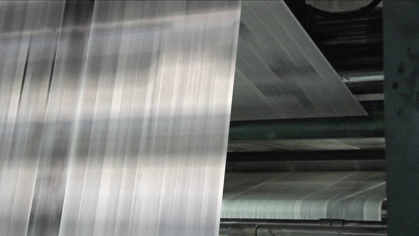 Newspapers move along an assembly line in a factory