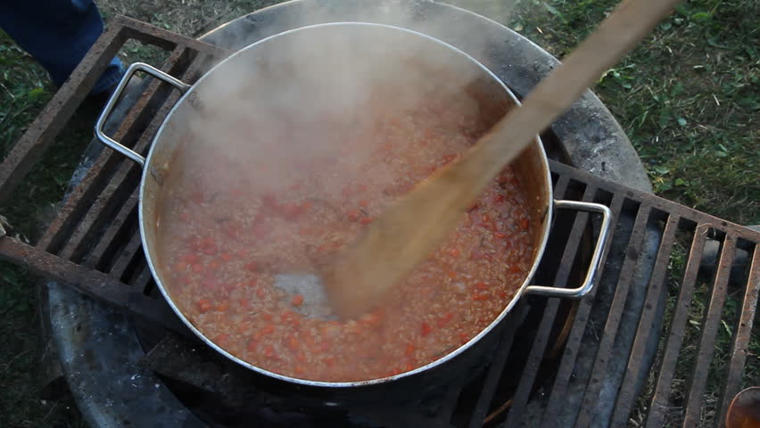 Cooking paella. Cooking large quantity of Spanish paella on an outdoor fire. 