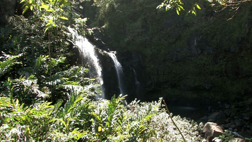 River running to Pacific Ocean through a set of waterfalls and pools before hitting Pacific ocean. Lush jungle rain forest.