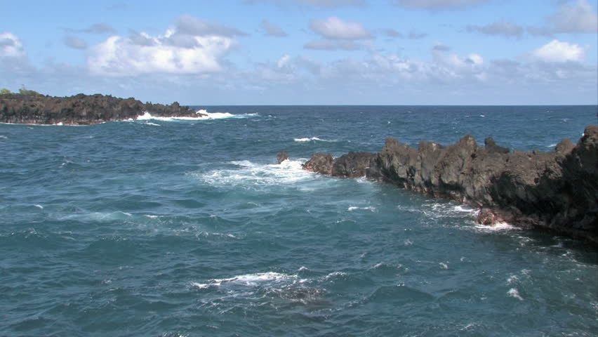 Rocky shoreline on the island of Maui in Hawaii.  Beautiful water. Waves splashing on rocks, scenic, relaxing and calm, beautiful tropical video. Pacific ocean bay or cove.