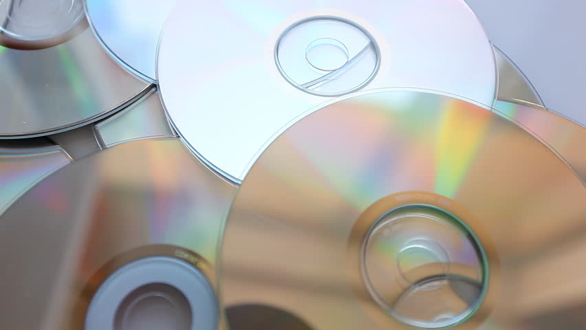 Compact disks fall on a table.