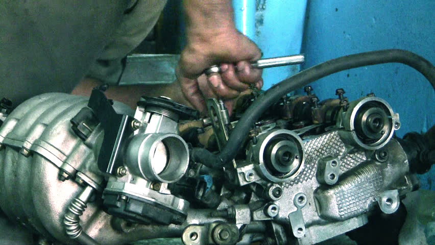 An unidentified auto mechanic repairing a car engine.