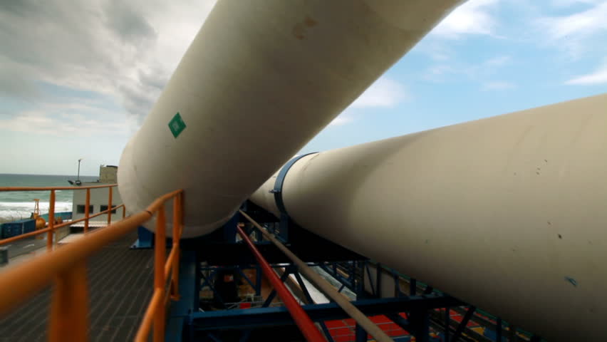 Slider dolly move left to right under two huge white water pipes at the IDE Ashkelon desalination plant in Israel.